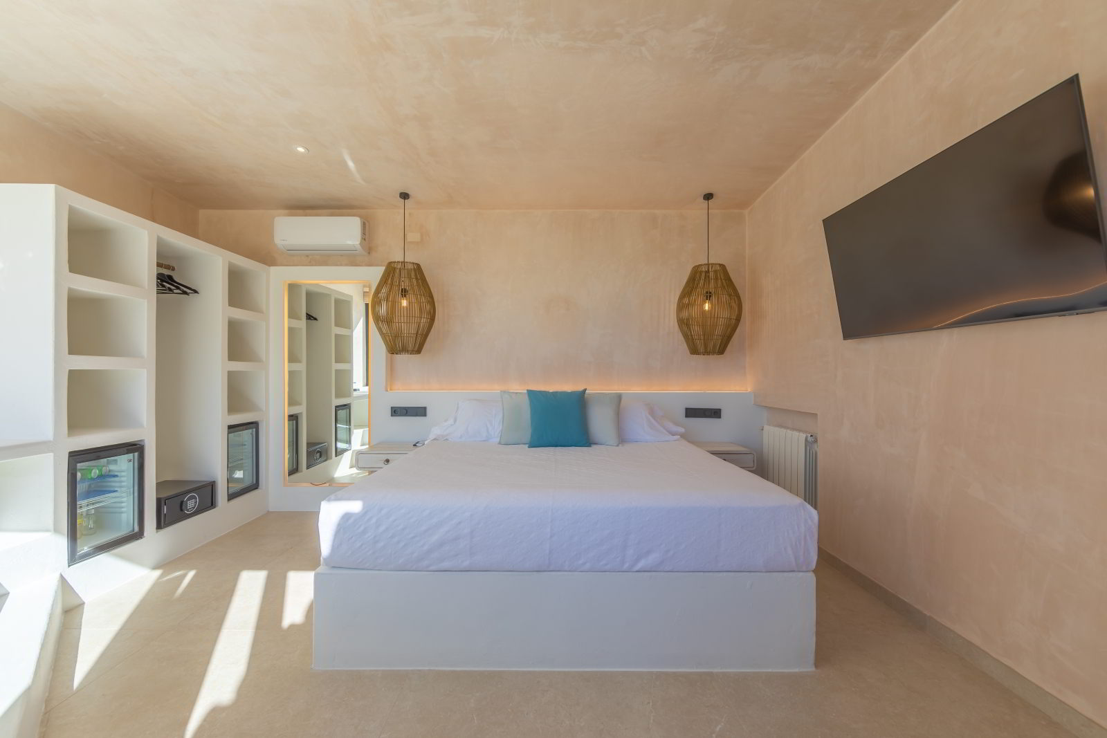 esDormitorio con cama doble, lámparas colgantes de fibras, televisor y espacio de almacenaje en La Villa del Hotel Punta Sur.