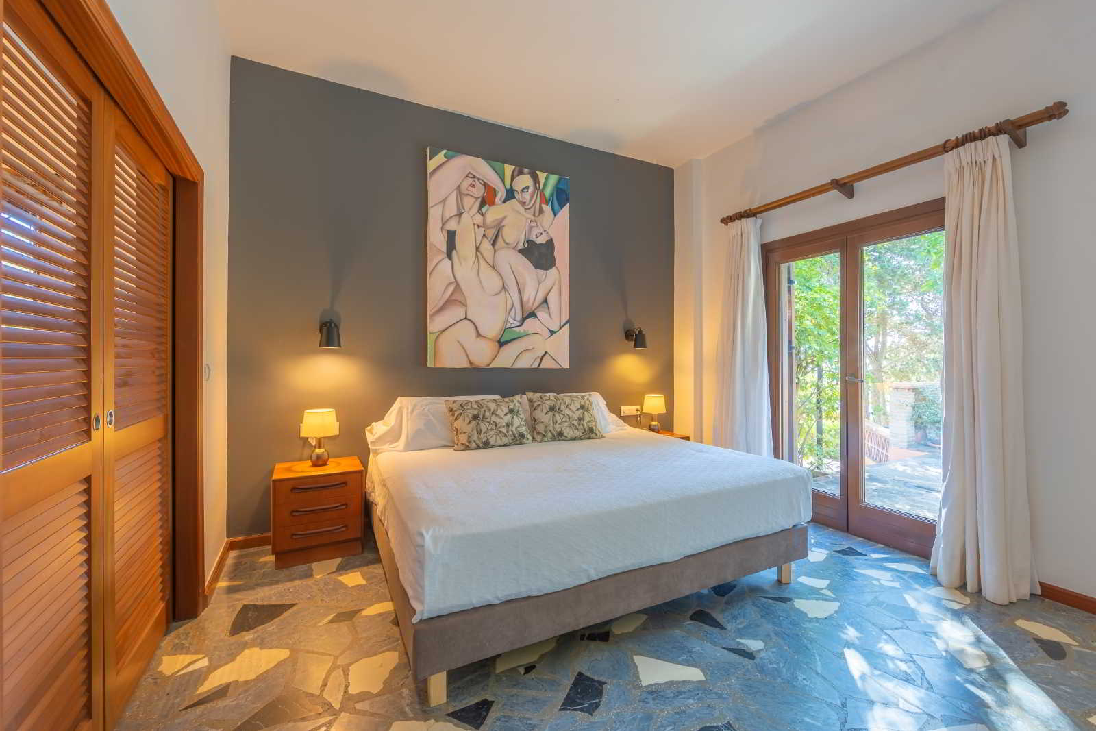 Dormitorio de habitación junior suite con cama doble, salida a terraza y luz natural en hotel Punta Sur
